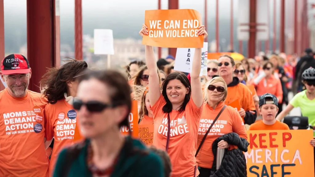 Marchers holding signs reading 'We Can End Gun Violence' at a Moms Demand Action rally