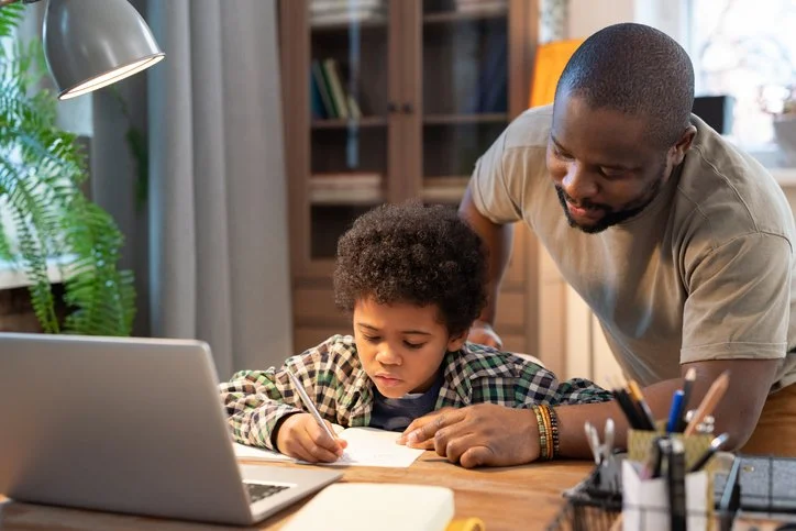 Parent helping a child with homework at a desk