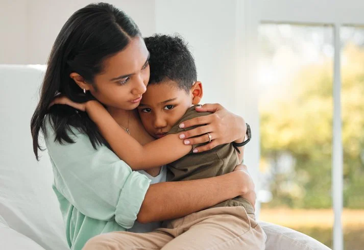 Parent comforting a child with a reassuring hug
