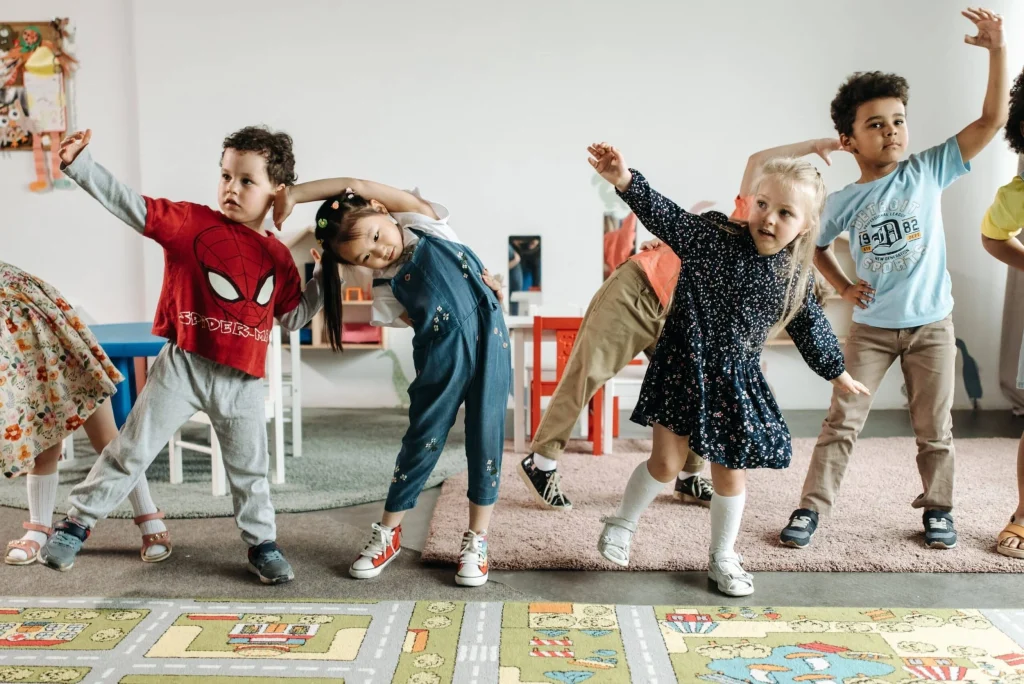 Group of children stretching and moving together in a classroom