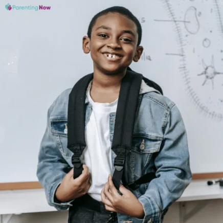 Smiling elementary school boy wearing a backpack in a classroom