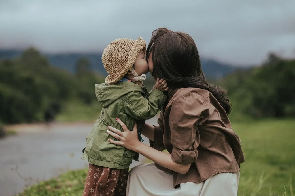 Mother and young child sharing an affectionate moment outdoors on a country path