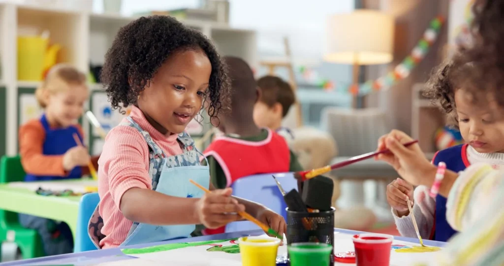 Children painting together at a classroom art table