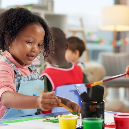 Children painting together at a classroom art table