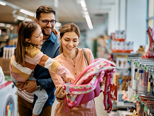 Family shopping together for a child's backpack in a store